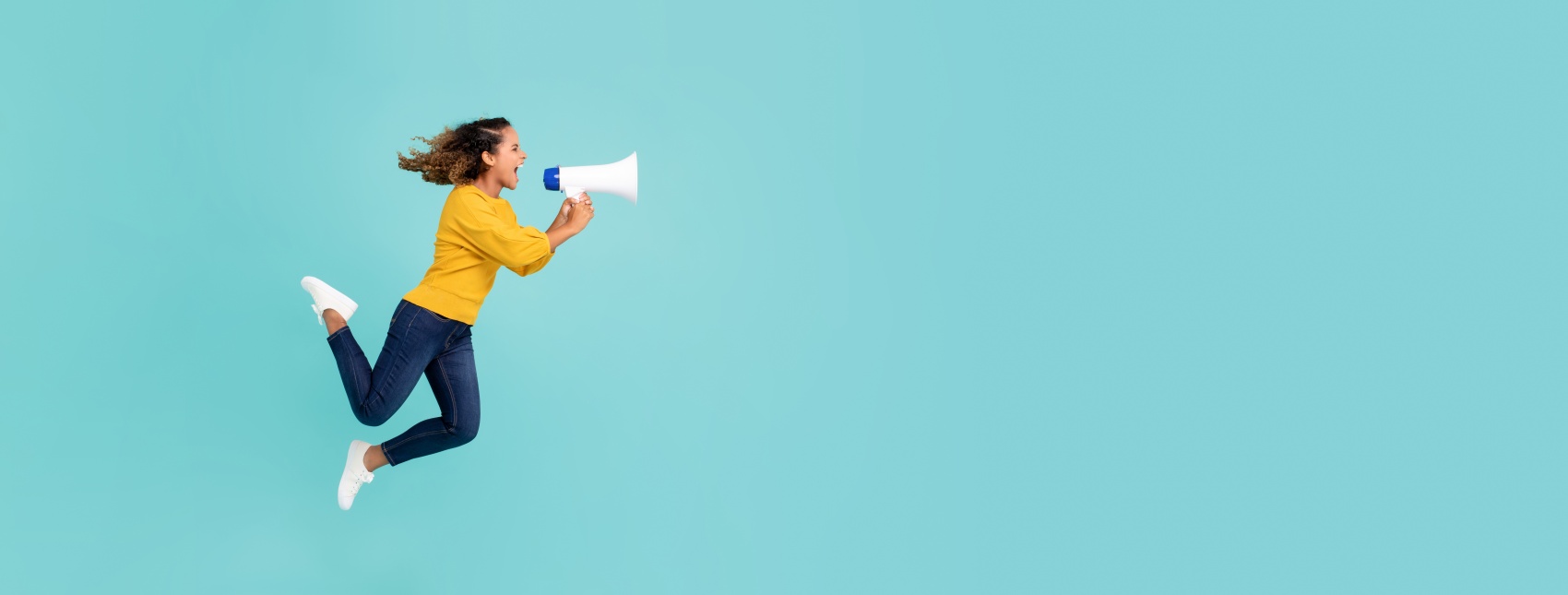 Girl with megaphone jumping and shouting